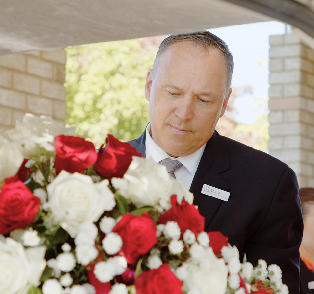 funeral director with bouquet of flowers