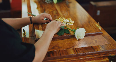 single white rose on top of coffin