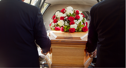 funeral director transferring a coffin into a hearse