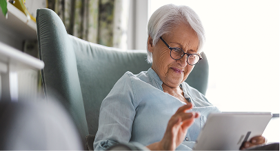 older woman examining a document while sitting comfortably