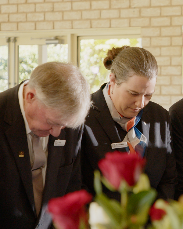 funeral directors paying their respects with heads bowed