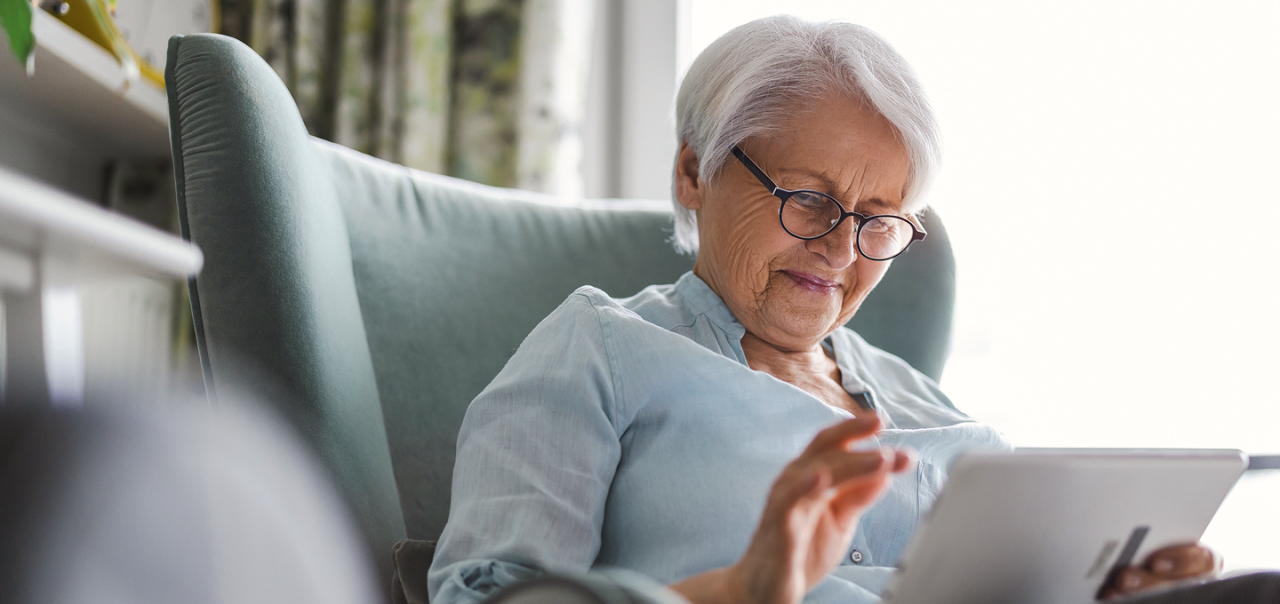 older woman watching on her ipad while seated