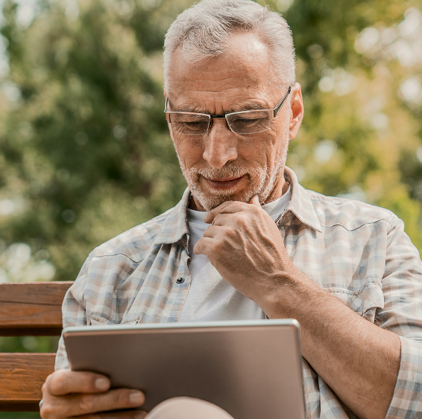 man holding a digital tablet with a reflective expression