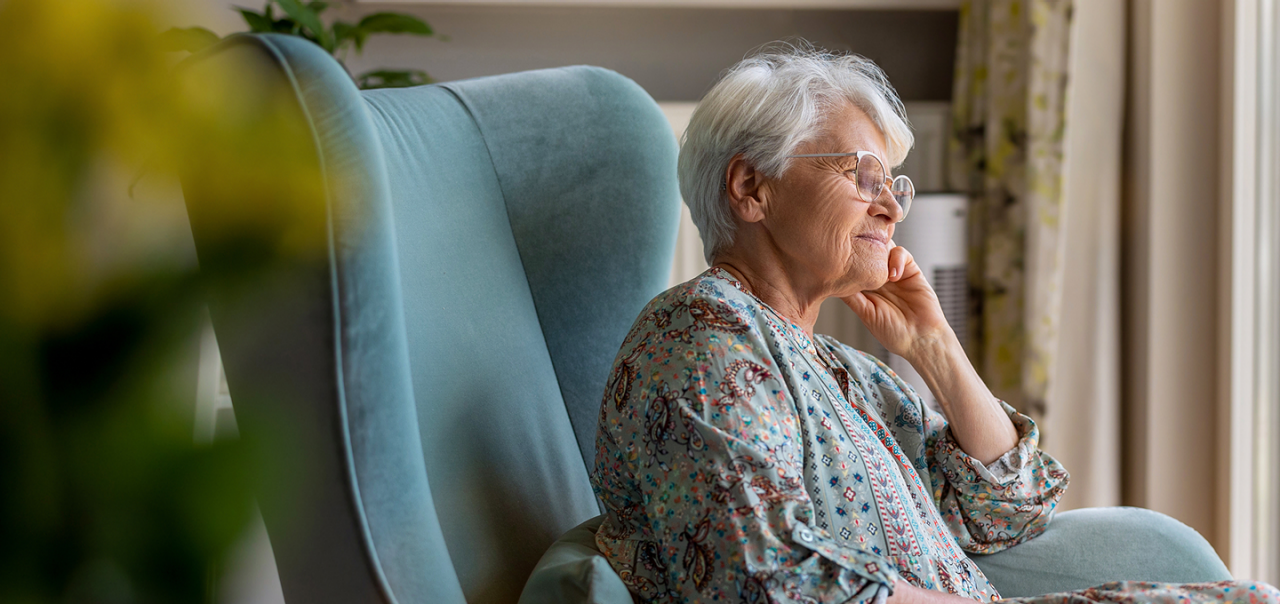elderly woman sitting thoughtfully
