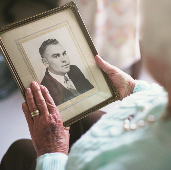 close-up of an elderly woman holding a photo frame