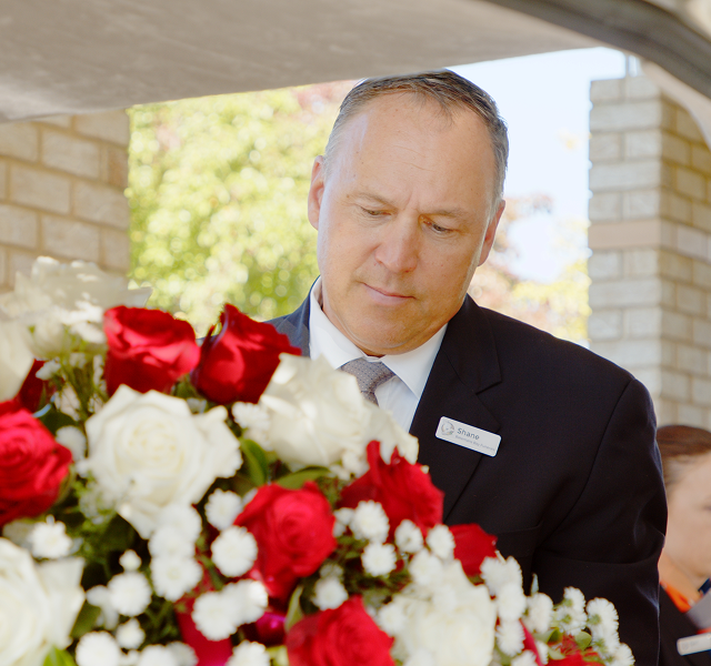 funeral director with bouquet of flowers